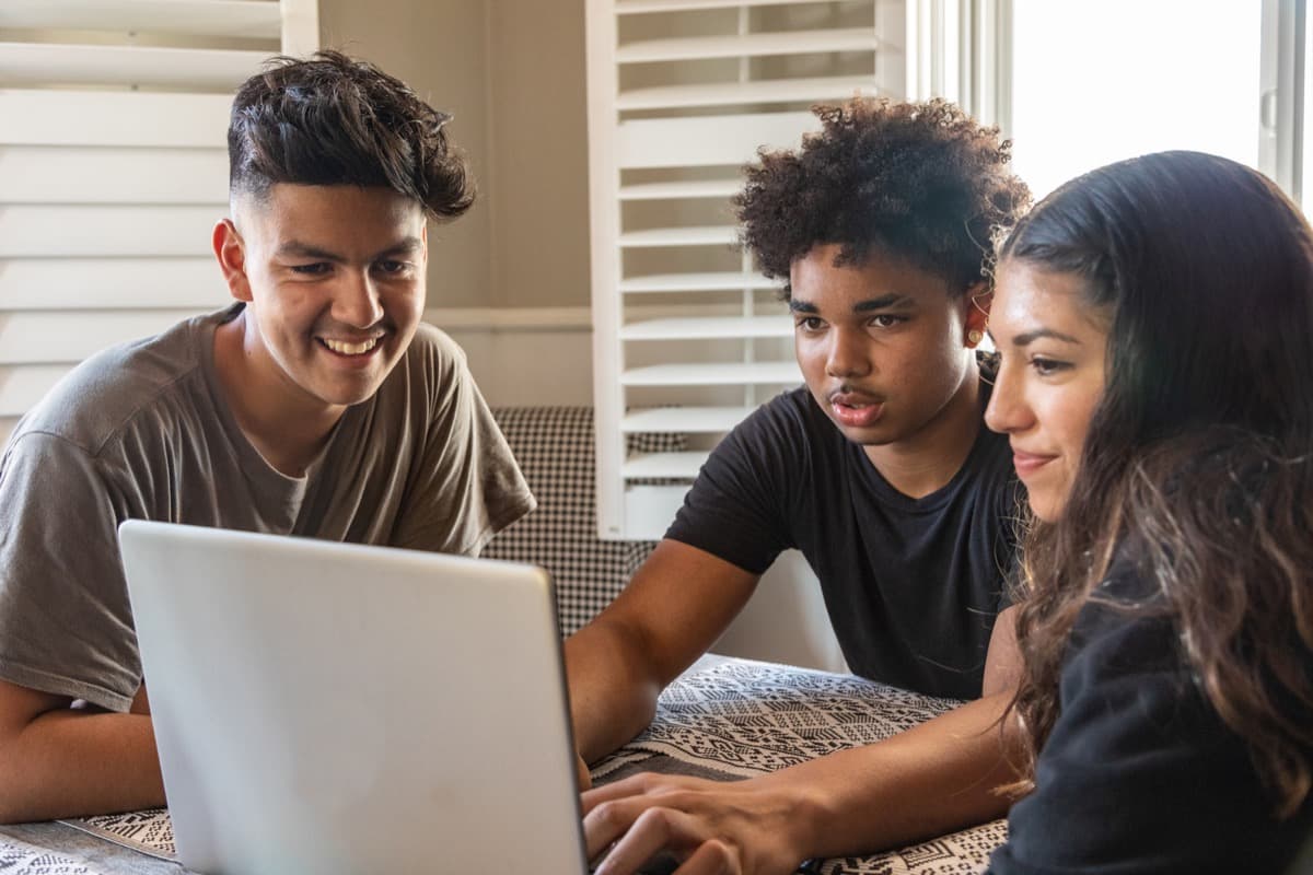 Students working together around a laptop